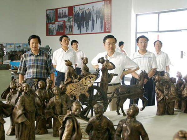 2008年8月5日山东省政协副主席、省工商联主席王乃静莅临华艺安博买球视察指导,傅绍相总经理介绍《风筝魂》群雕